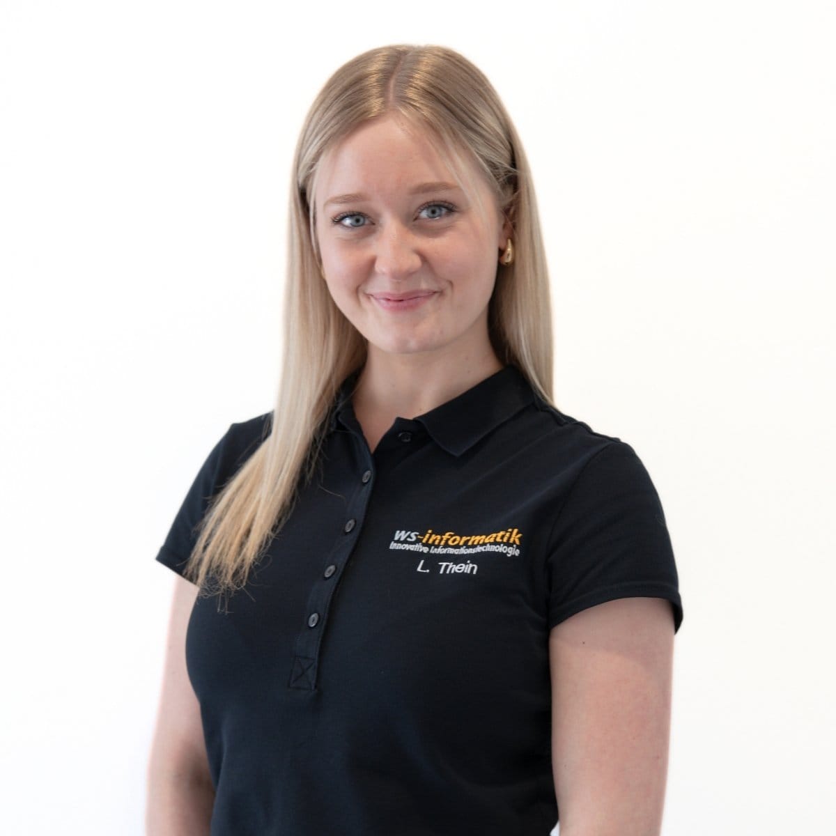 Portrait von Lea, Assistenz der Geschäftsführung bei der WS-Informatik GmbH & Co. KG, im schwarzen Poloshirt mit Firmenlogo, vor weißem Hintergrund.