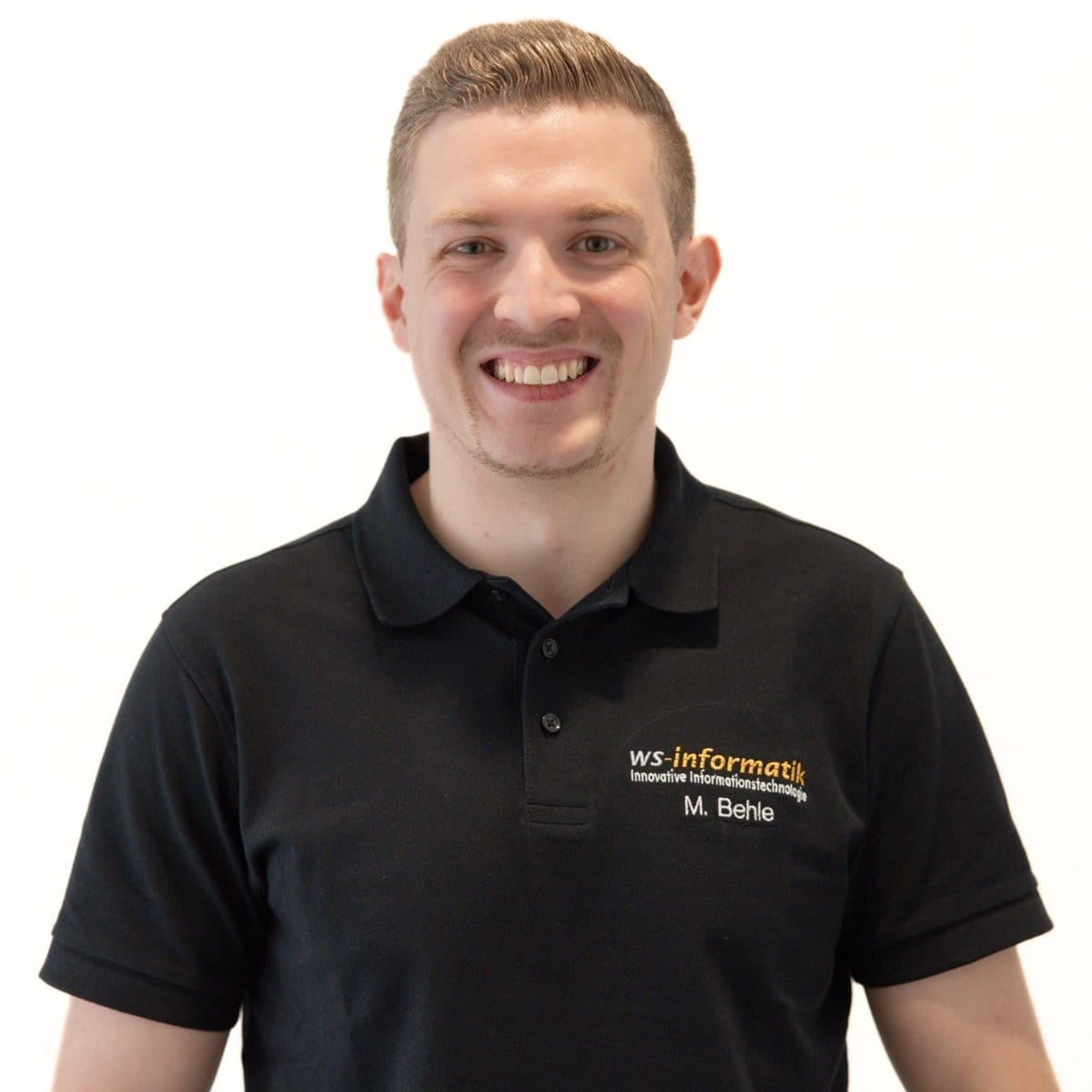 Portrait von Marvin, Servicetechniker bei der WS-Informatik GmbH & Co. KG, im schwarzen Poloshirt mit Firmenlogo, vor weißem Hintergrund.
